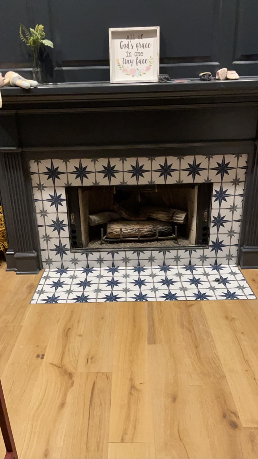 Custom star-pattern tile fireplace surround with new light-oak plank flooring