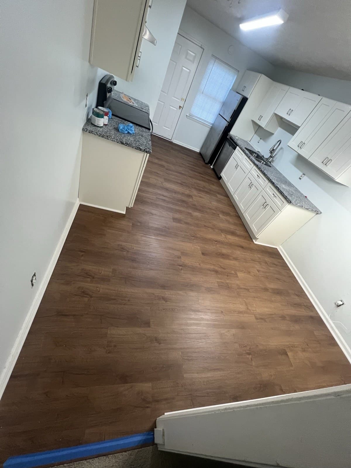 Wood-look LVP flooring in a kitchen with white shaker cabinets