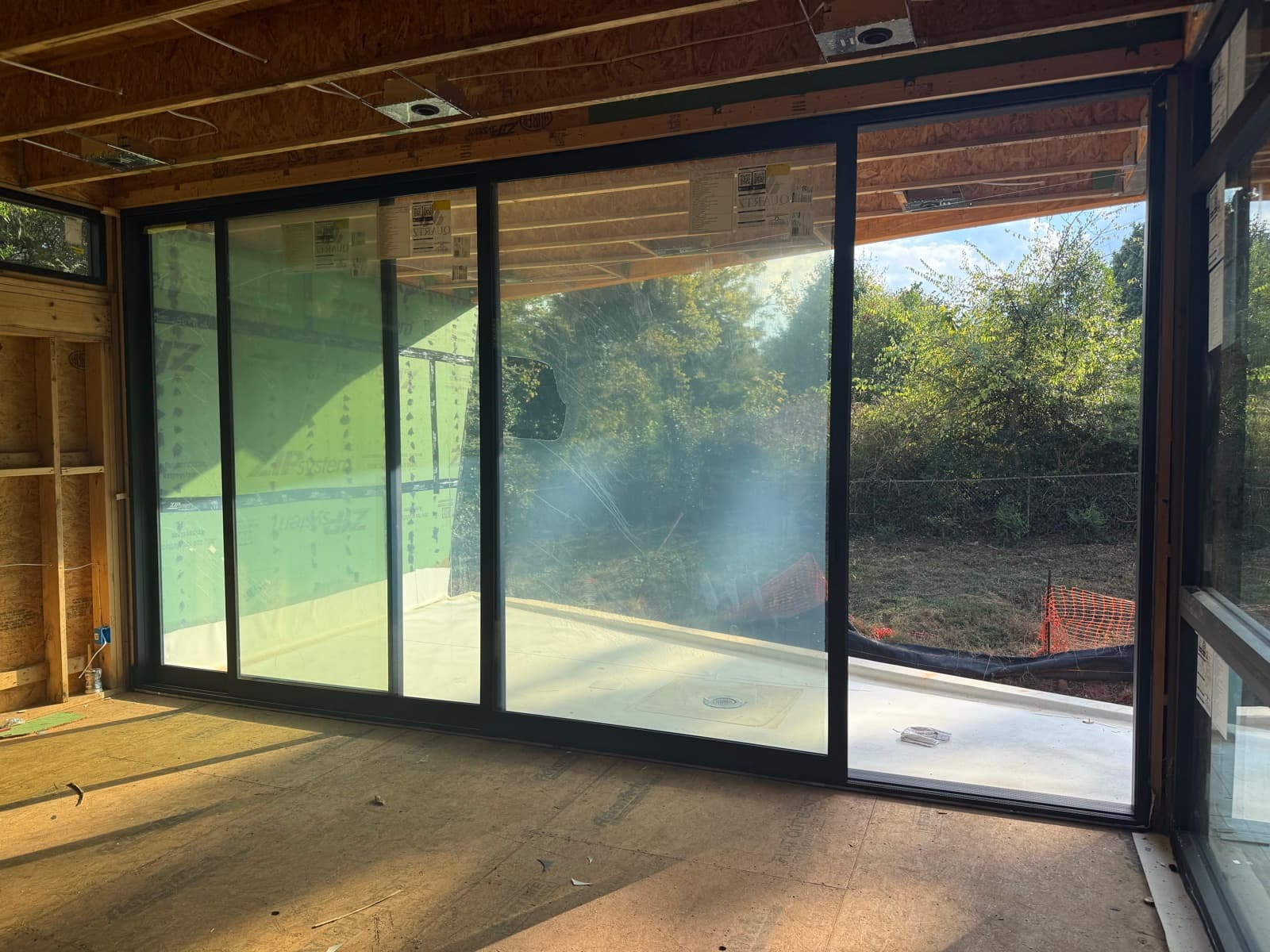 Black-framed multi-panel sliding glass patio door installation