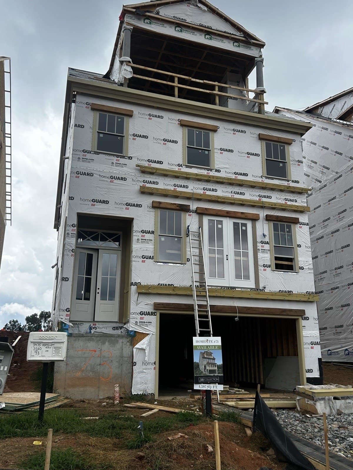 Housewrapped new-construction home with windows and front door set